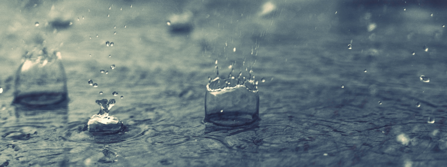 Regentropfen fallen ins Wasser.