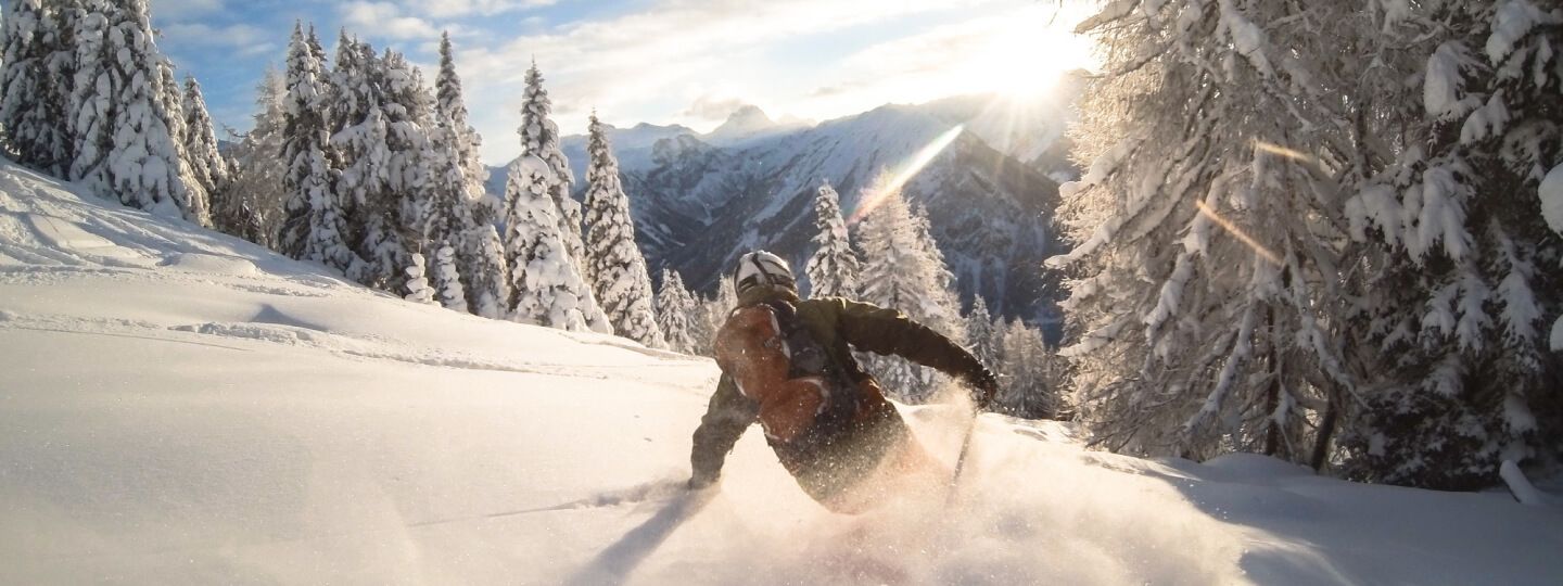 Skifahrer fährt im Tiefschnee in einer Berglandschaft 
