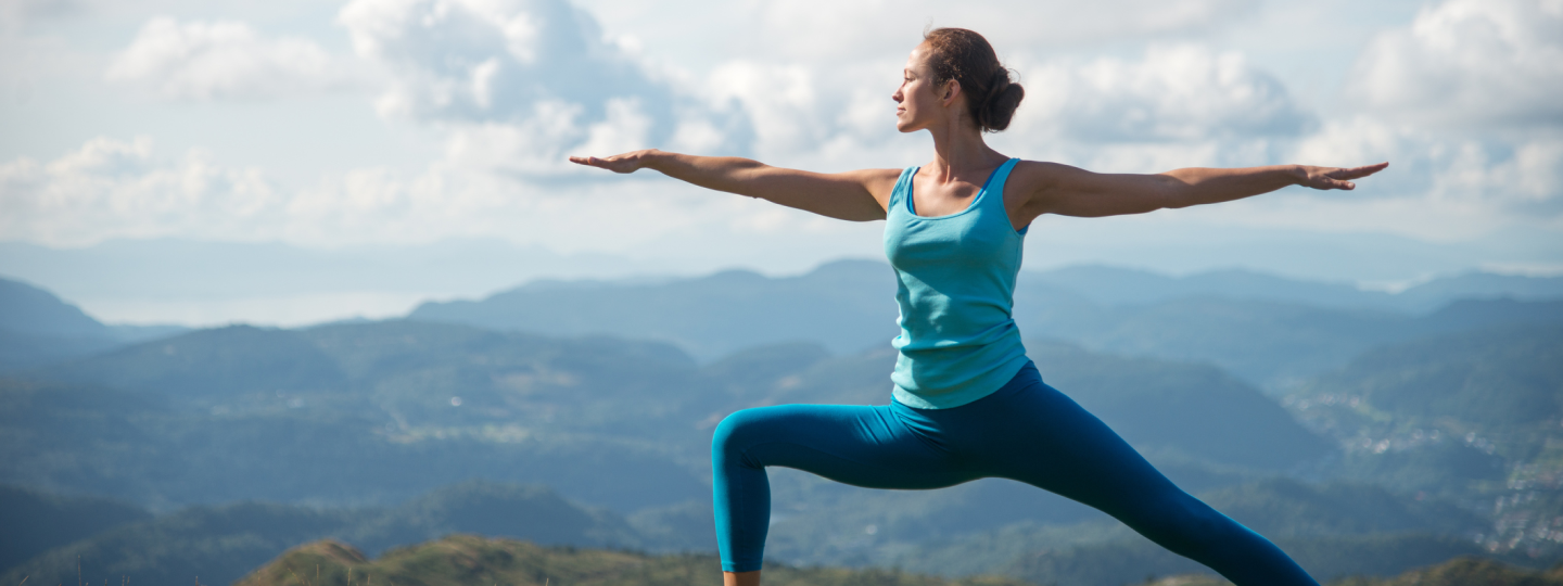 Frau macht Yoga auf dem Berg