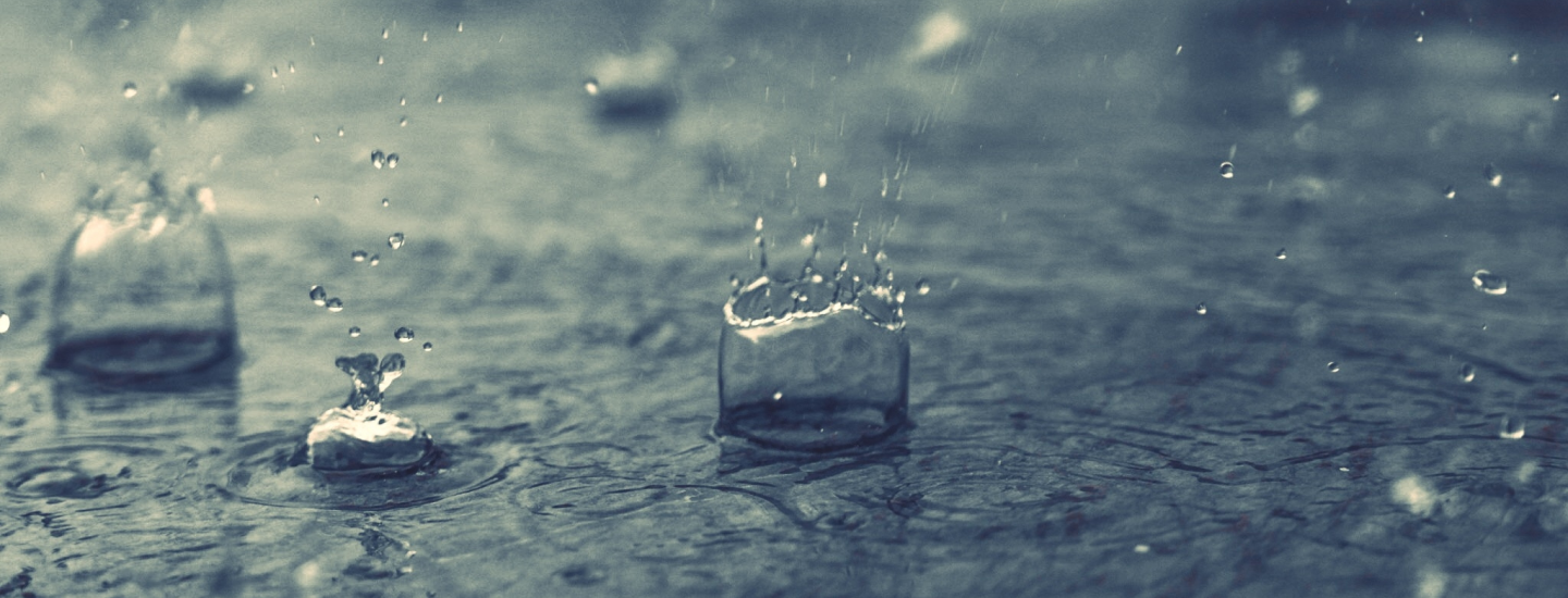 Regentropfen fallen ins Wasser.