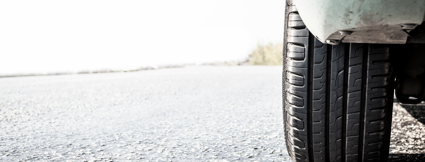 Detailansicht von einem Hinterreifen auf einer Straße.