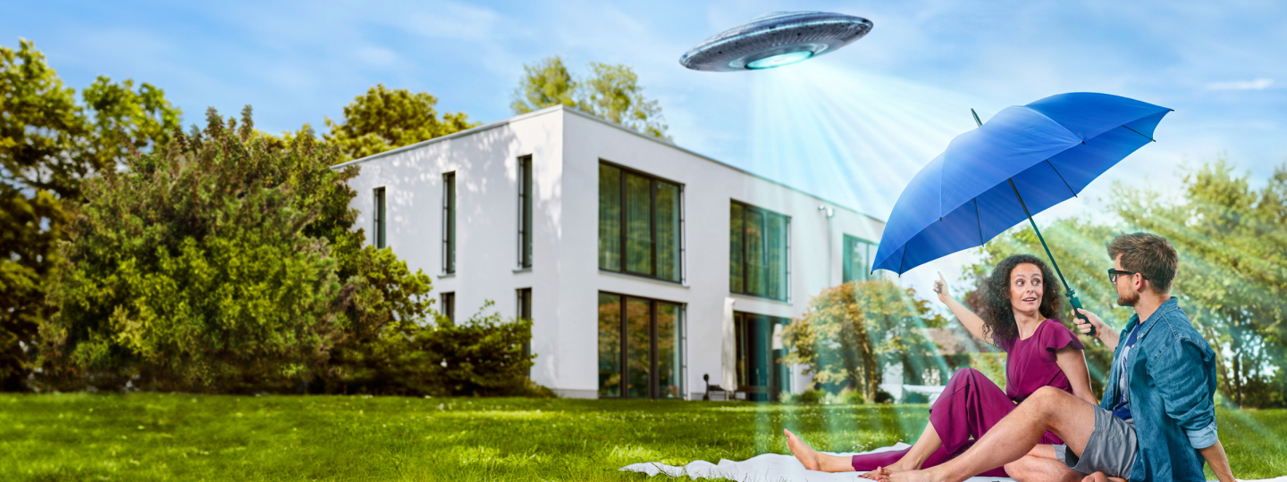 Mann und Frau in einem Garten mit blauem Schirm und über ihnen ein Ufo