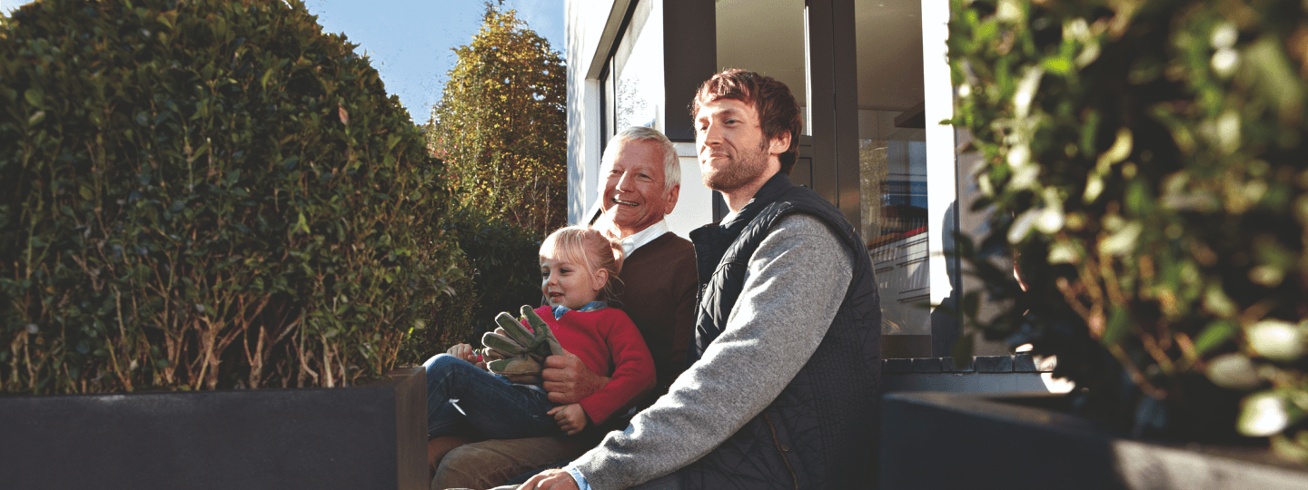 Opa, Vater und Enkel zusammen vor ihrem Haus