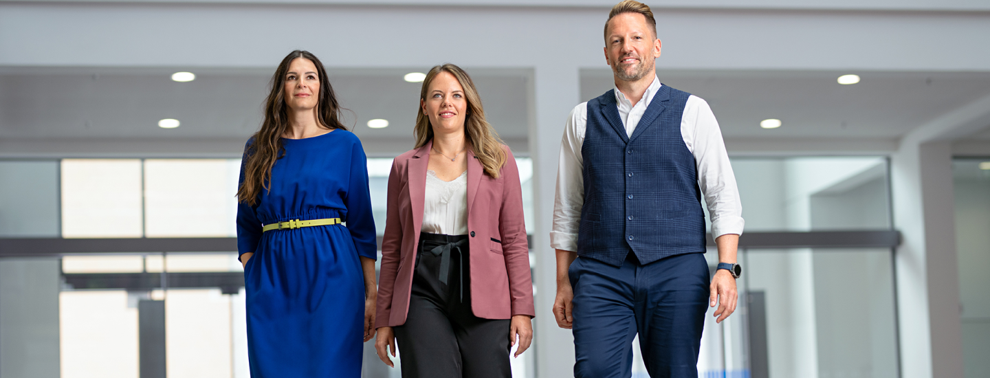 Drei Konzernmitarbeiter im VKB-Gebäude in München