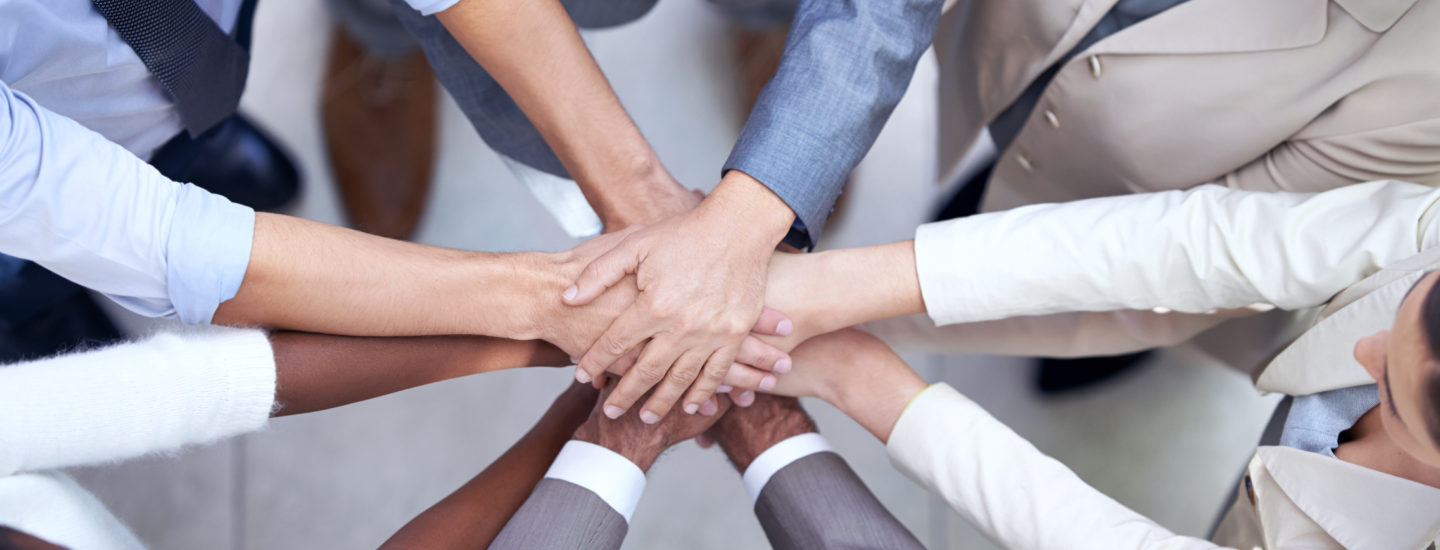 Hände von einem halben Dutzend Menschen treffen sich in der Mitte