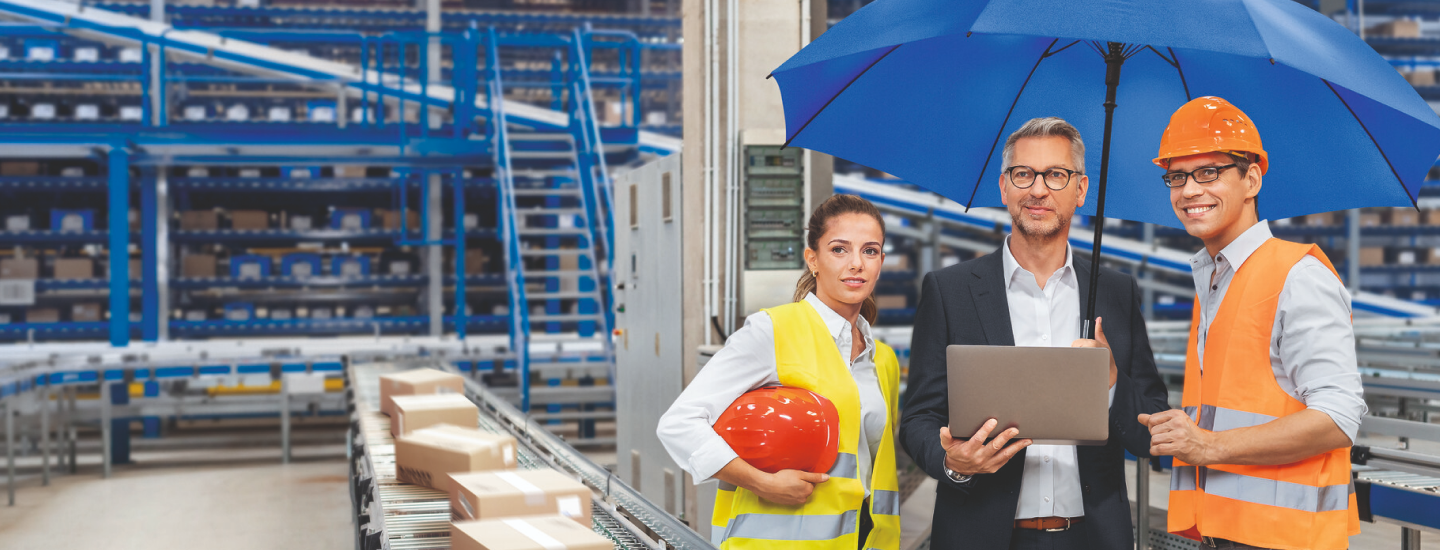 Mehrere Arbeiter unter einem blauen Schirm in einem Firmengebäude