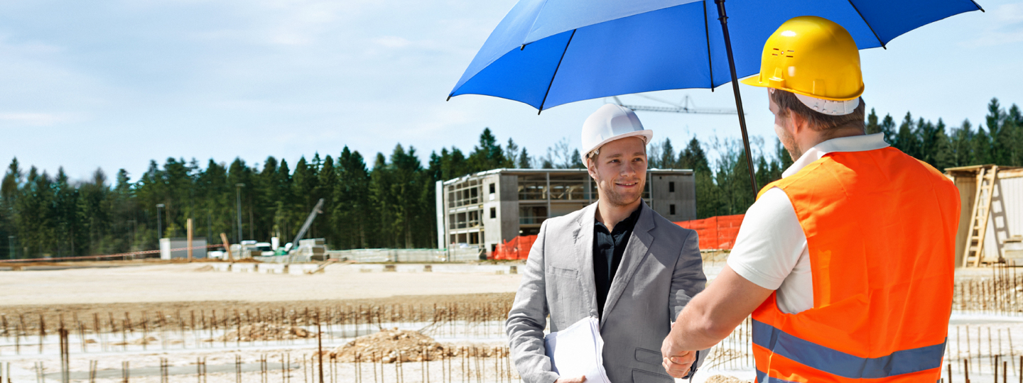 Zwei Männer mit Helmen unterhalten sich unter dem blauen Schutzschirm