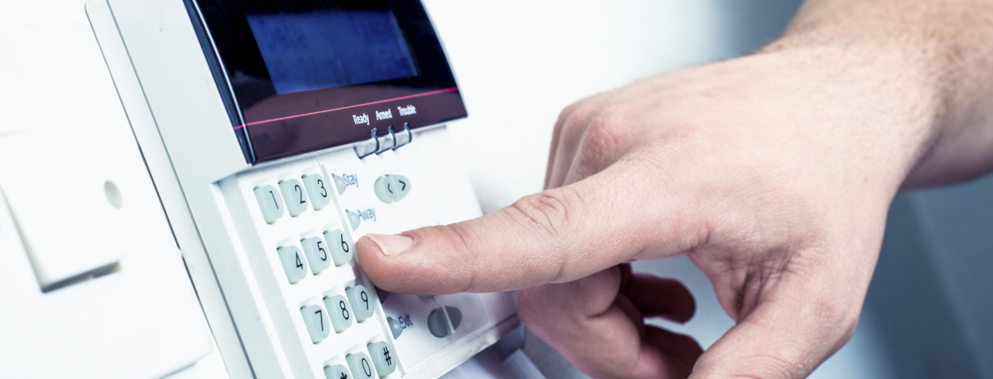 Jemand tippt Zahlencode in eine Alarmanlage ein.