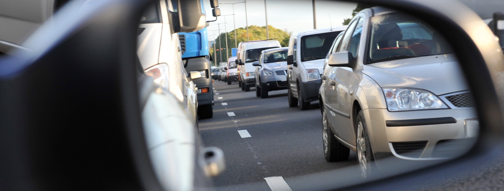 Rechter Seitenspiegel eines Autos in dem sich der Stau spiegelt.