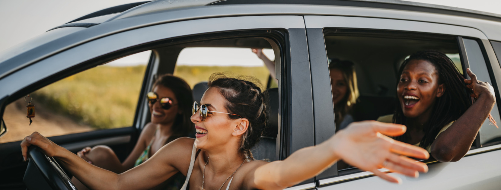 Vier fröhliche Frauen im Auto auf einem Roadtrip.