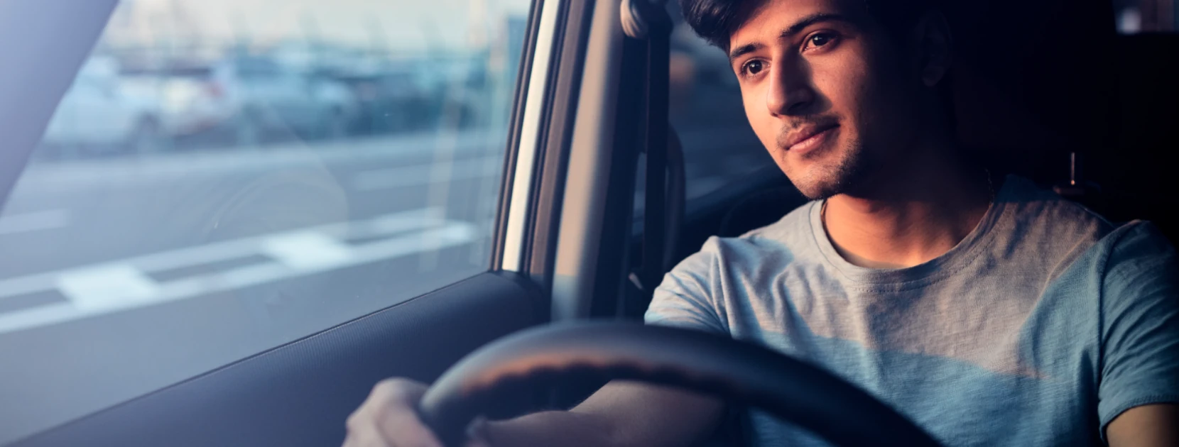 Junger Mann sitzt am Steuer