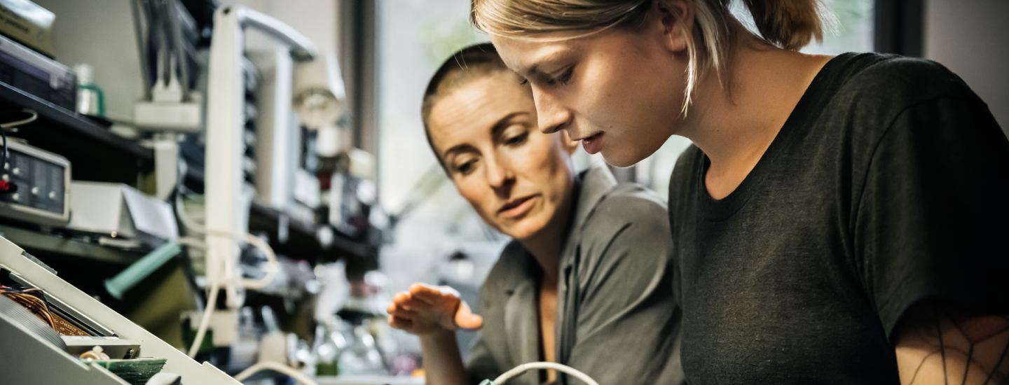 Ausbilderin zeigt junger Frau das Löten.