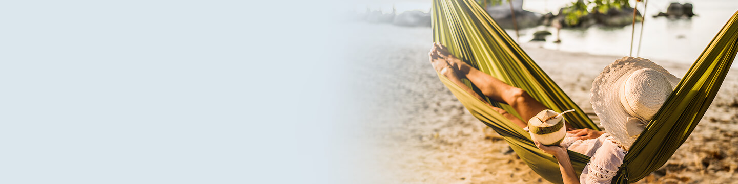 eine Frau liegt in einer Hängematte am Strand